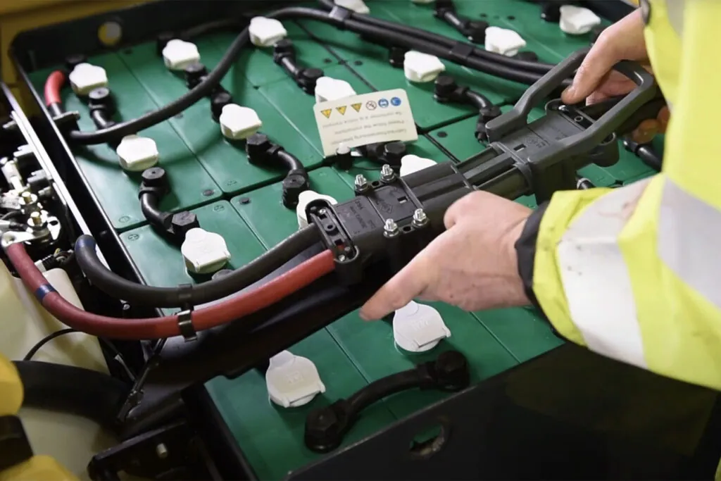 forklift battery getting plugged in to truck.