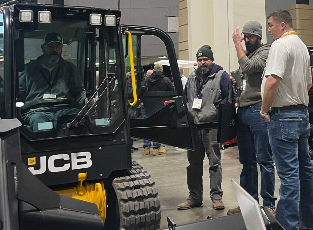 Northern Green 2025 Expo attendee inside JCB 2TS-7T Teleskid cab at Fairchild Equipment's booth.