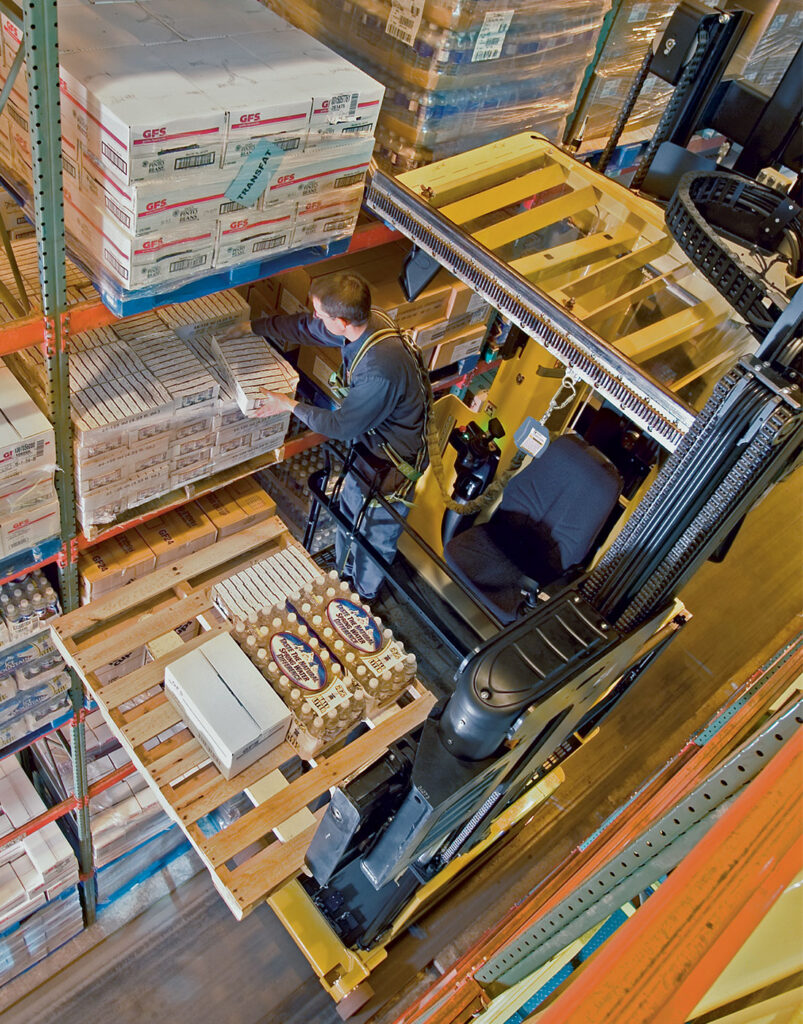 Man picking off rack with Yale NTA Very Narrow Aisle turret truck.