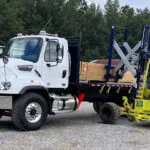 Donkey The Jack forklift placing lumber on a truck trailer.