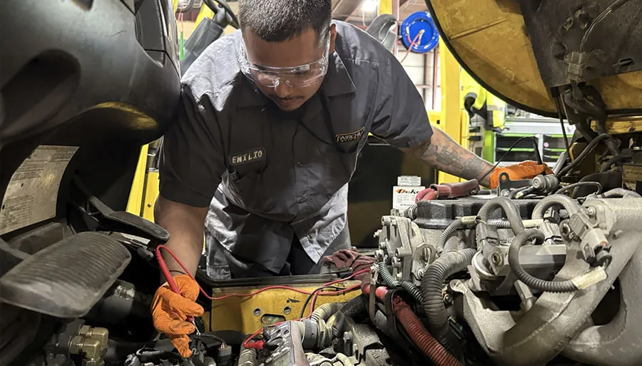 Technician inspecting forklift.