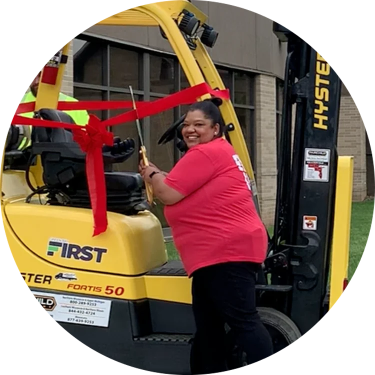 Amber Coplen cutting the ribbon on the donated Hyster forklift from Fairchild Equipment.
