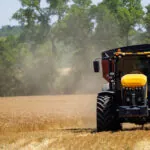 JCB 8330 Fastrac agricultural tractor driving across field.