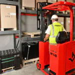 Mariotti MIP 10 compact electric forklift lifting pallet onto warehouse pallet racking.